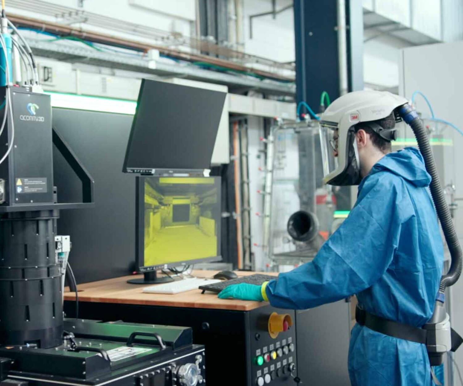 Mann in Schutzkleidung steht vor einer Maschine im Laser Zentrum. Titelbild eines Produktfilms Hannover von 52° Film für INLEAP Photonics.