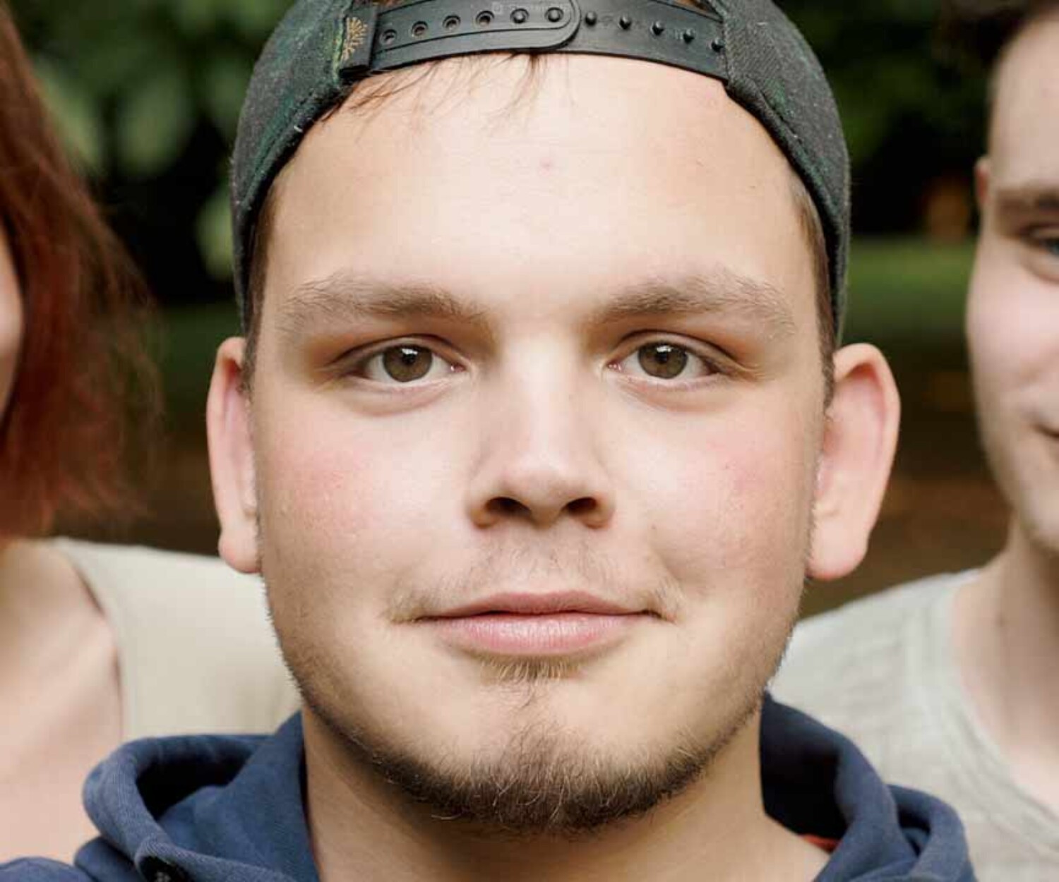 Drei Auszubildende vom Wurst-Basar stehen in Nahaufnahme vor der Kamera, eine Person blickt direkt hinein. Titelbild einer Recruitingvideo-Produktion Hannover von 52° Film.